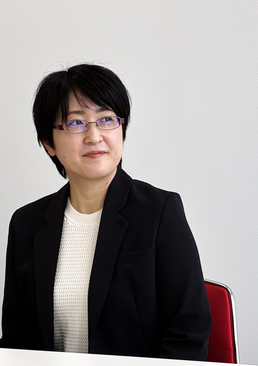 会議室でほほえみながら話を聞く石松 良子