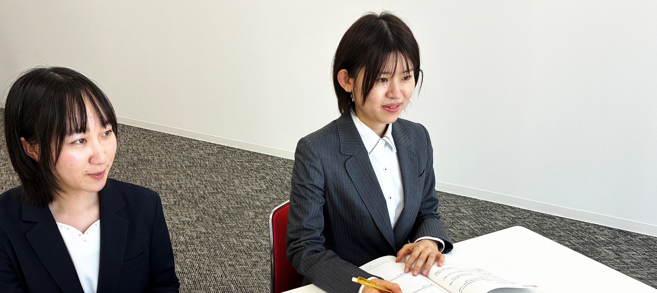 研修テキストを前に、笑顔で打ち合わせをするICSのメンバー