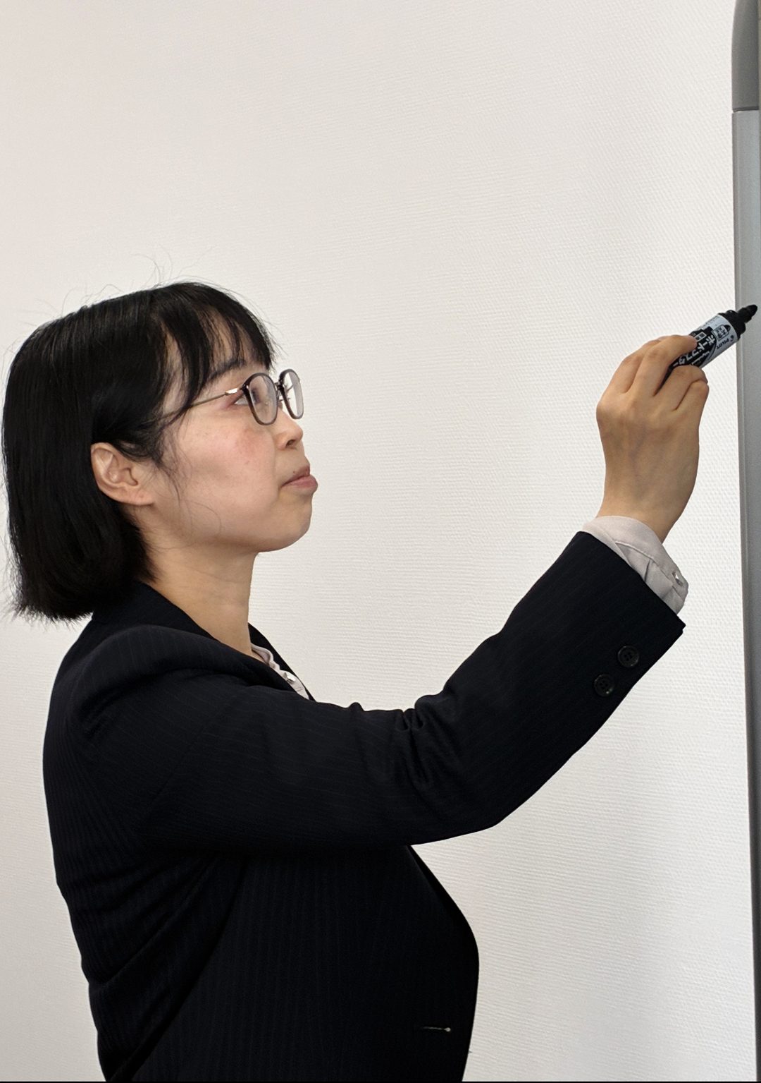ホワイトボードに書き込む執行役員の矢野 由香里